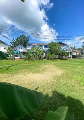 a view of a yard with houses in the background at Karon House 15B in Karon Beach