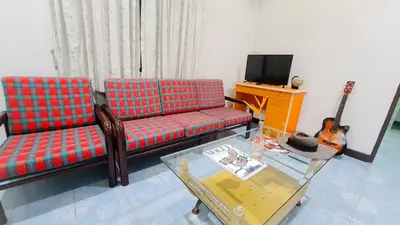 a living room with a couch and a guitar at Karon House 15B in Karon Beach