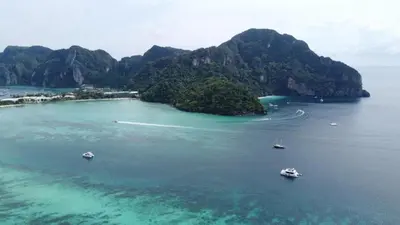 an island with boats in a large body of water at Phi Phi Seaside Bungalow in Phi Phi Don
