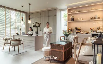 two people standing in a room with a table at Villa Alanna Phuket in Bang Tao Beach