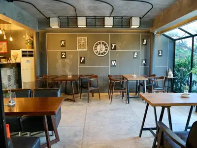 a restaurant with tables and chairs and a clock on the wall at Z&Z Resort in Rawai Beach
