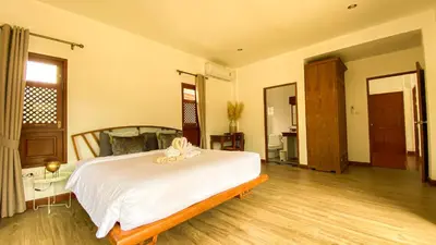 a bedroom with a large white bed in a room at Tropical garden in Phuket Town