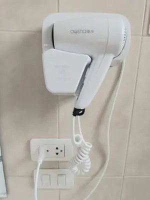 a white hair dryer on a wall in a bathroom at Udomsuk villa phuket in Bang Tao Beach