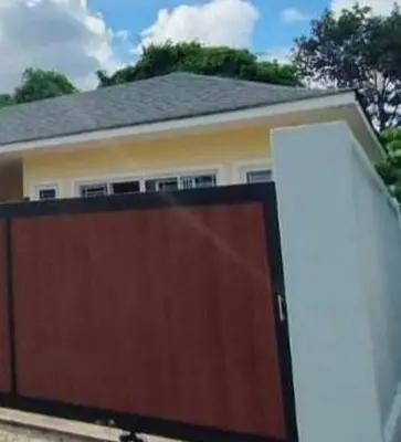 a house with a wooden garage door in front of it at Udomsuk villa phuket in Bang Tao Beach