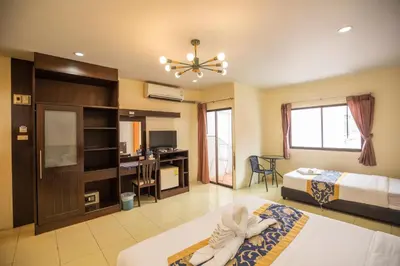 a hotel room with two beds and a desk at Lily Holiday hotel \u767e\u5408\u5047\u65e5\u9152\u5e97 in Patong Beach