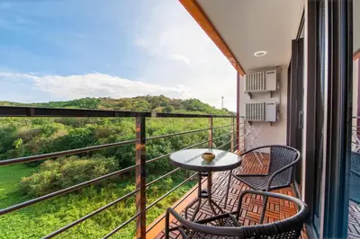 a balcony with two chairs and a table at Nai Harn Beach Condominium in Nai Harn Beach