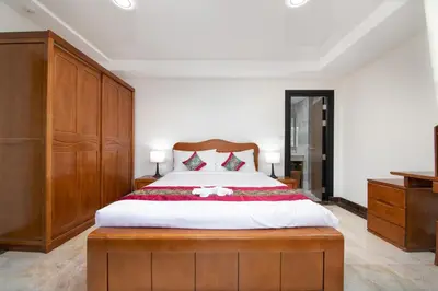 a bedroom with a large bed with a wooden headboard at Nai Harn Beach Condominium in Nai Harn Beach