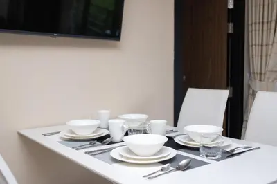 a table with white bowls and plates on it at Nai Harn Beach Condominium in Nai Harn Beach