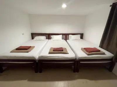 a bedroom with two beds with white sheets at Phi Phi Paradise Hostel in Phi Phi Don