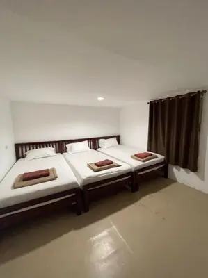 two twin beds in a room with a window at Phi Phi Paradise Hostel in Phi Phi Don