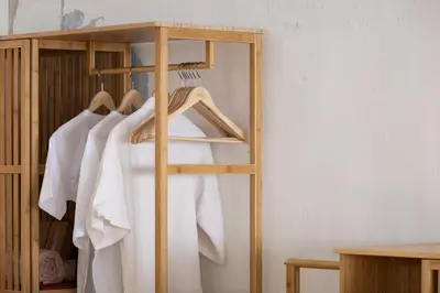 a wooden clothes rack with white shirts on it at 97 Yaowarat - Phuket Old Town in Phuket Town