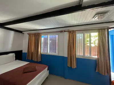 a bedroom with a bed and two windows at PhiPhi Film House in Phi Phi Don