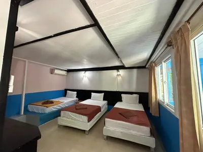 a room with three beds in a room at PhiPhi Film House in Phi Phi Don