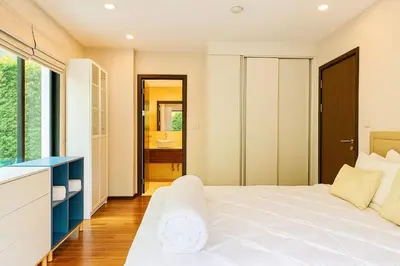 a bedroom with a large white bed and a bathroom at The Title Rawai Beachfront (Sea paradise) in Rawai Beach