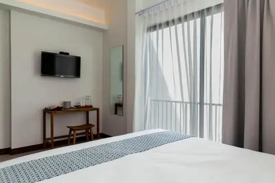 a bedroom with a bed and a tv on a wall at Baan Kamana Guest House in Phangnga