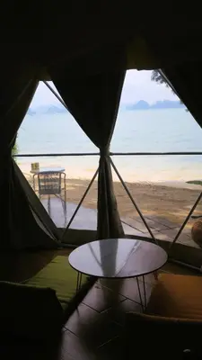a tent with a table and a view of the beach at Touch Glamping Koh Yao Noi ทัช แกรมปิ้ง เกาะยาวน้อย in Ko Yao Noi