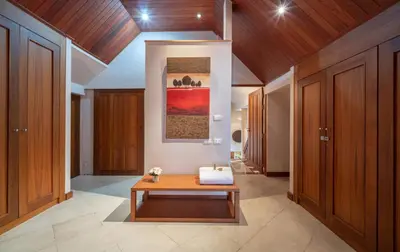 a hallway with a table in a room with wooden cabinets at Beachfront Kalim Beach Villa in Patong Beach