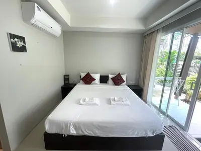 a bedroom with a bed with two towels on it at Naiyang Boutique Resort in Ban Phak Chit