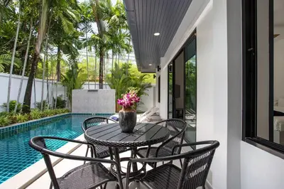 a patio with a table and chairs next to a pool at Villa Elima. Lovely pool villa 2 bedrooms at Rawai in Rawai Beach