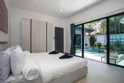a bedroom with a white bed and a swimming pool at Villa Elima. Lovely pool villa 2 bedrooms at Rawai in Rawai Beach