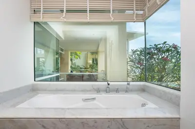 a bath tub in a room with a large window at Happy Apartment on Karon Beach in Karon Beach