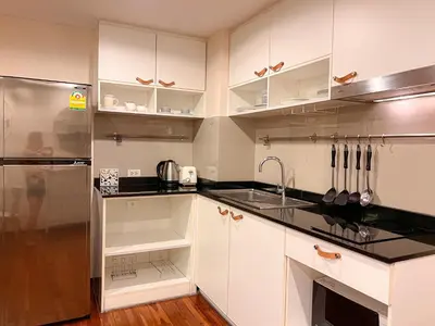 a kitchen with white cabinets and a stainless steel refrigerator at The Title Rawai: Beachfront condotel in Rawai Beach