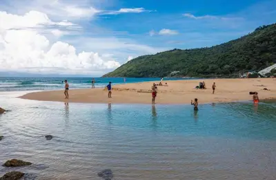 a group of people playing in the water on a beach at Poly Villa Naya 3 in Rawai Beach