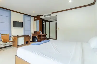 a bedroom with a bed and a desk and a television at Goodday Kathu in Kathu