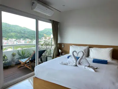 two swans towels sitting on a bed in a bedroom at Patong Tower apartment by Lofty in Patong Beach