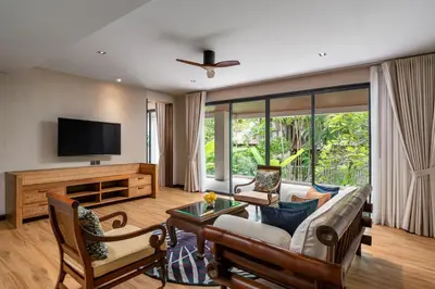 a living room with a couch and a tv at Noku Phuket in Chalong