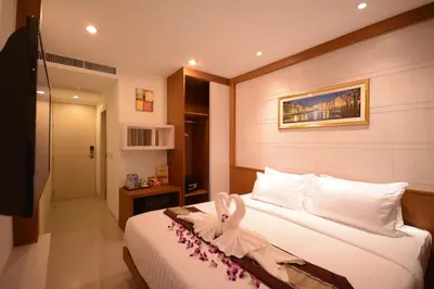 a hotel room with a bed with a bow on it at The Patong Center Hotel in Patong Beach