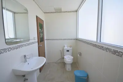 a white bathroom with a sink and a toilet at The Patong Center Hotel in Patong Beach