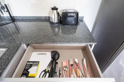 a drawer in a counter with a box with utensils at Tropical Living Surin Beach Phuket in Surin Beach