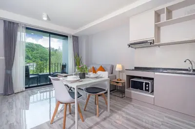 a kitchen and dining room with a table and chairs at Tropical Living Surin Beach Phuket in Surin Beach