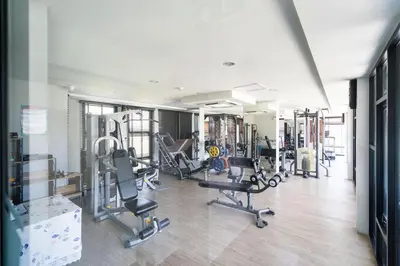 a gym with several treadmills and cardio machines at Tropical Living Surin Beach Phuket in Surin Beach