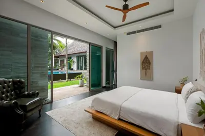 a bedroom with a bed and a ceiling fan at Stunning 5BR villa with freshwater pool & tropical garden in Ban Phru Champa