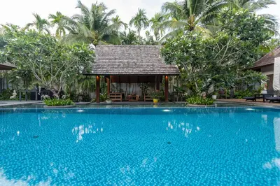 a swimming pool in front of a villa at Stunning 5BR villa with freshwater pool & tropical garden in Ban Phru Champa