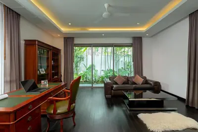 a living room with a desk and a couch at Stunning 5BR villa with freshwater pool & tropical garden in Ban Phru Champa