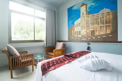 a bedroom with a bed and a picture of a building at Beehive Phuket Old Town Hostel in Phuket Town
