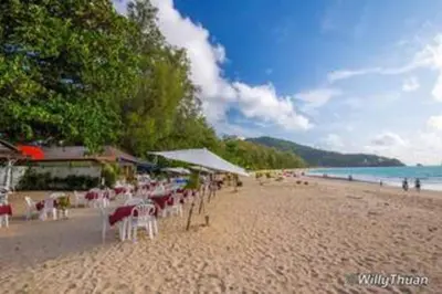 a beach with a lot of chairs and umbrellas at Nayang Beach Brand New Executive Luxury Condo in Nai Yang Beach