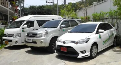 two white vehicles parked next to each other at Green House Phuket in Ban Pa Khlok