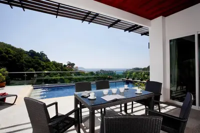 a patio with a table and chairs and a pool at Phuket Kamala, Spectacular Seaviews, Private pool, 3 BR in Kamala Beach