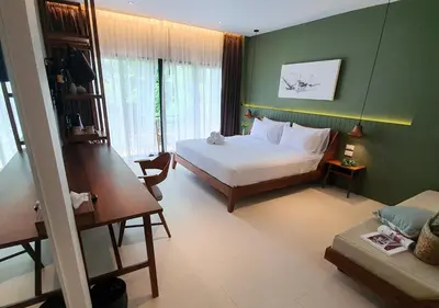 a bedroom with a white bed and a green wall at Mini House Aonang Hotel SHA Plus in Ao Nang Beach