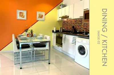 a kitchen with a table and a washing machine at Tranquil Condo close to Beach in Kamala Beach