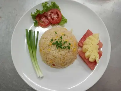 a white plate of food with rice and vegetables at Kata Place Hotel in Kata Beach