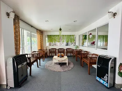 a dining room with a table and chairs and a tv at Kata Place Hotel in Kata Beach