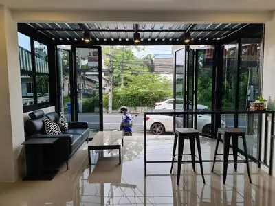 a living room with a couch and some stools at ก้านกล้วยแมนชั่น Gankluy Mansion in Phuket Town