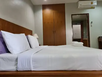 a large bed with white sheets and pillows at ก้านกล้วยแมนชั่น Gankluy Mansion in Phuket Town