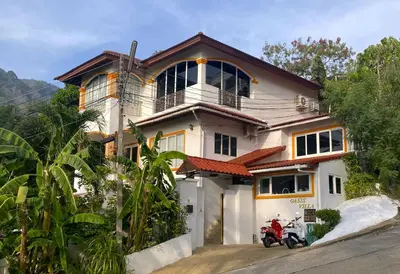 a house with a motorcycle parked in front of it at OASIS VILLA Karon Beach in Karon Beach