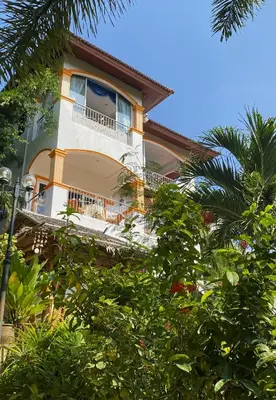 a building with a balcony and trees at OASIS VILLA Karon Beach in Karon Beach